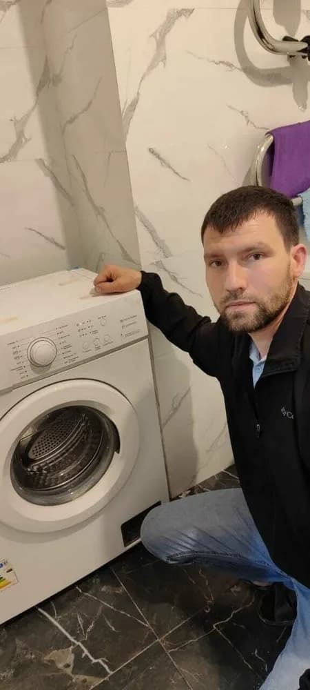 Алексей проверяет стиральную машину после ремонта